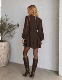 Back view of the Wilde mini dress in cocoa bean, featuring lace inset sleeves, a keyhole button closure and thin self-tie waist.