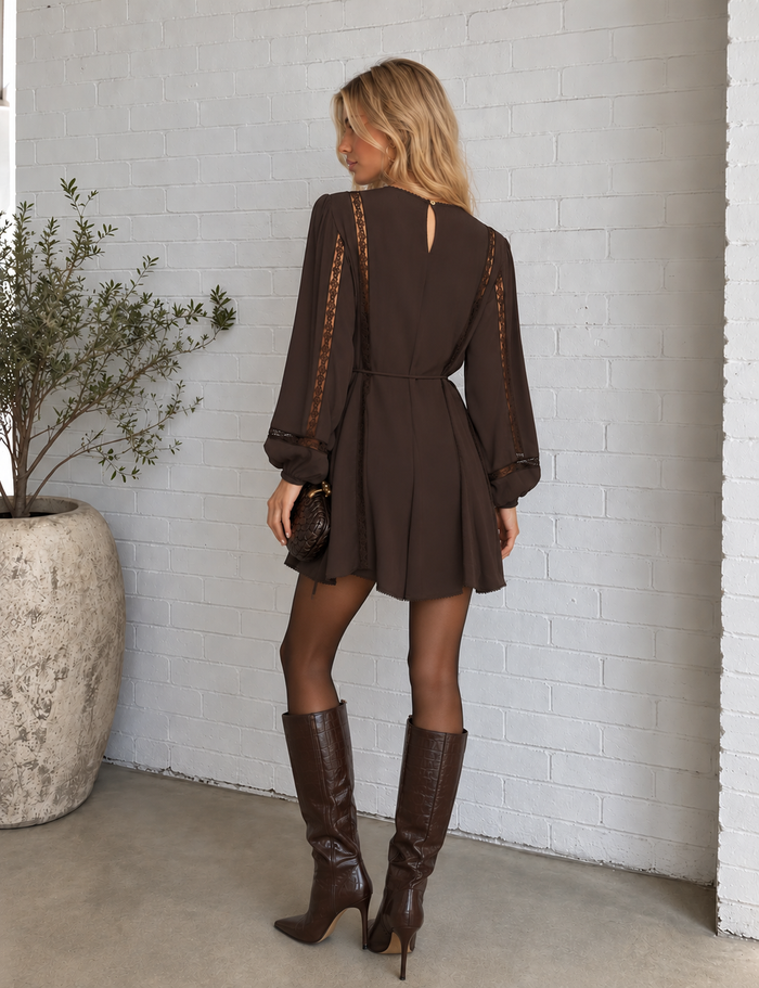 Back view of the Wilde mini dress in cocoa bean, featuring lace inset sleeves, a keyhole button closure and thin self-tie waist.