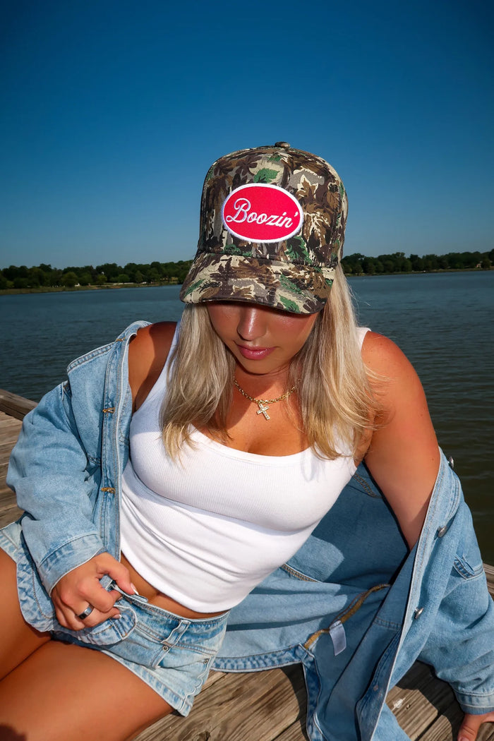 Camouflage baseball cap featuring a red Boozin' graphic patch on the front, a curved brim, and a classic casual design.
