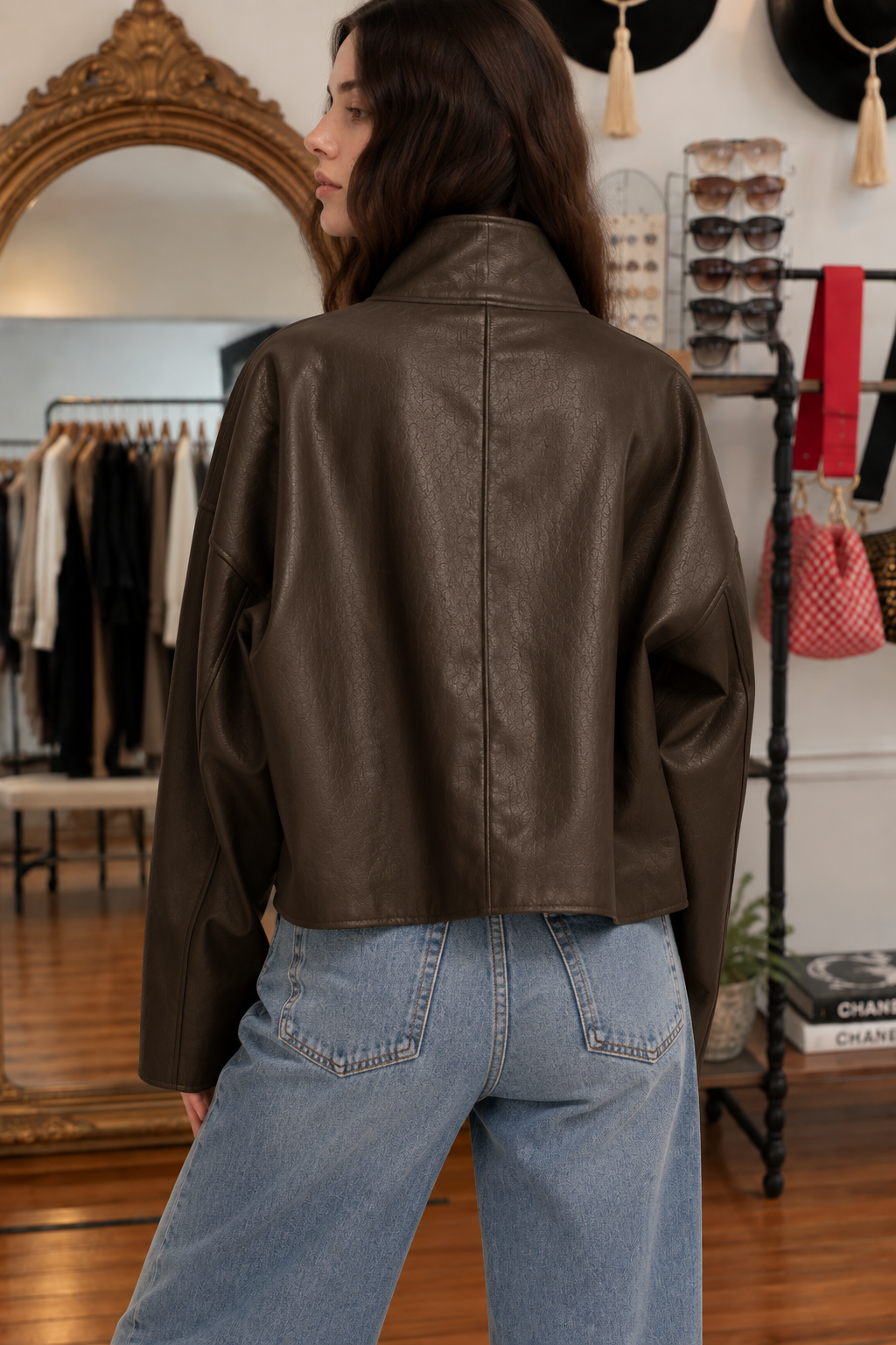 Back view of chocolate brown oversized coated jacket with high collar and relaxed fit, styled with blue denim jeans
