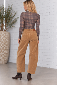 Back view of a model wearing the Harper Corduroy Cropped Barrel Pants in fawn, featuring textured corduroy fabric, back patch pockets, curved barrel-leg silhouette, and cropped length.