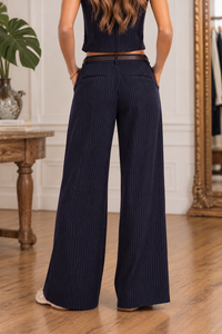 Back view of the Legacy navy pinstripe pants featuring fine ivory vertical stripes, a relaxed wide-leg silhouette, and full-length hems.