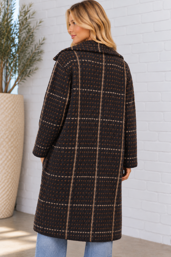 Back view of the Marceau Houndstooth Coat in black multi on a blonde model, showcasing the plush textured knit, geometric pattern, vertical stripe detailing, and knee-length design.