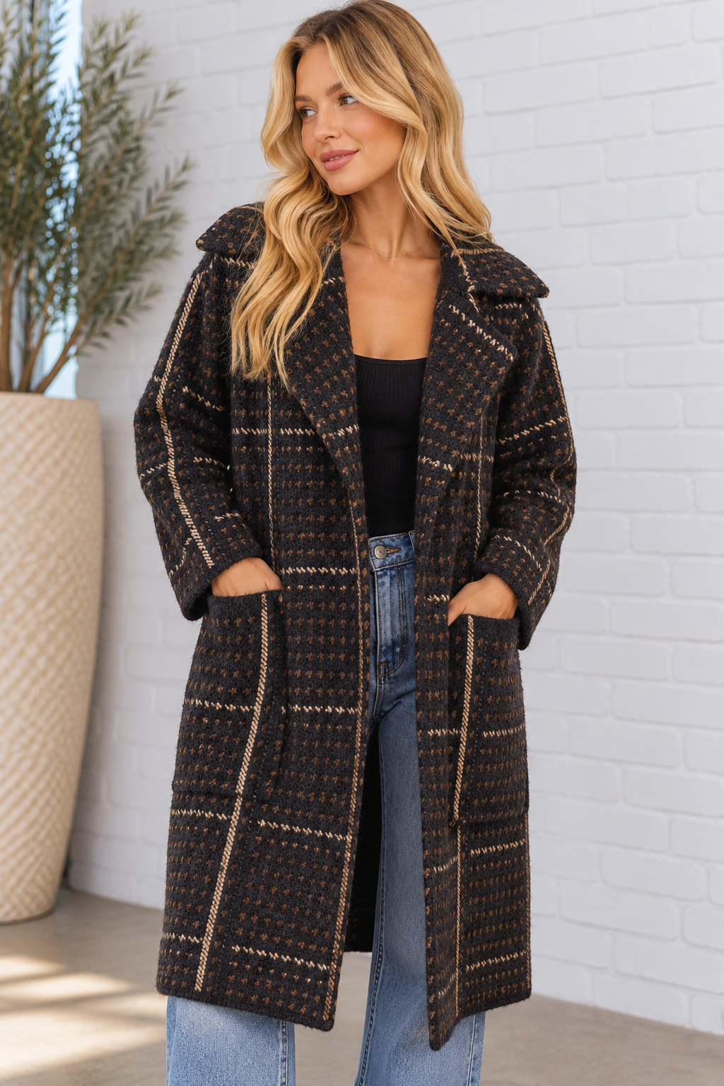Back view of the Marceau Houndstooth Coat in black multi on a blonde model, showcasing the plush textured knit, geometric pattern, vertical stripe detailing, and knee-length design.