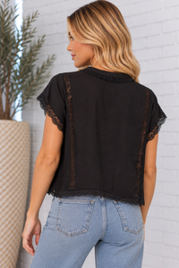 Back view of the Valentina Top in black, featuring vertical lace inset panels, delicate lace-trimmed sleeves, and a slightly cropped hem with scalloped lace edging.