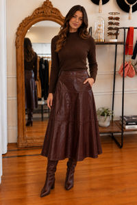 Dark brown mock neck sweater styled with a brown midi skirt and boots