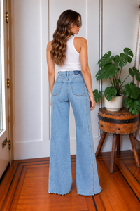 Back view of Far Out Make Believe light wash high rise wide leg jeans with back patch pockets and raw hem