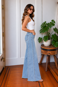 Side view of Far Out Make Believe light wash wide leg jeans showing elongated side panel seam and raw hem