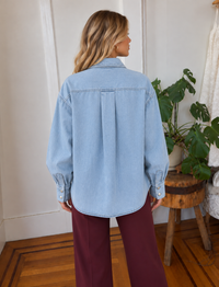 Back view of Merritt Osalina light wash denim shacket with center pleat and curved hem