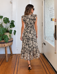 Back view of Painted Fields black floral midi dress with flutter sleeves and flowing tiered skirt